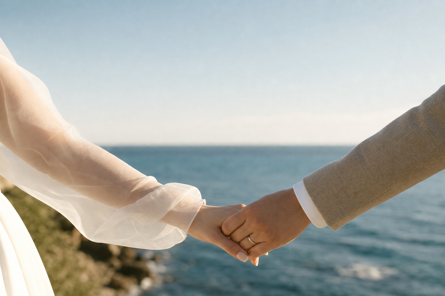 Manos de una pareja unidas frente al mar